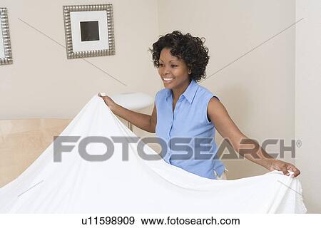 Stock Photo - Woman making a bed. Fotosearch