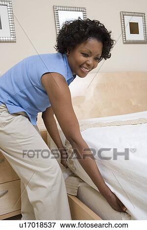 Stock Photo - Woman making a bed. Fotosearch