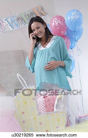 Stock Photography - Woman on mobile phone at baby shower. Fotosearch