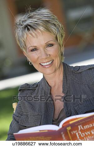 Stock Photo - Woman smiling outdoors, portrait. Fotosearch