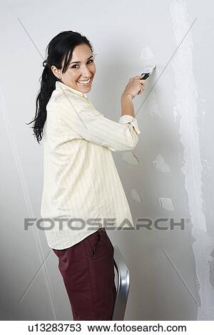 Woman standing on ladder, speckling interior wall View Large Photo Image Stock Image - Woman standing on ladder, speckling interior wall. Fotosearch