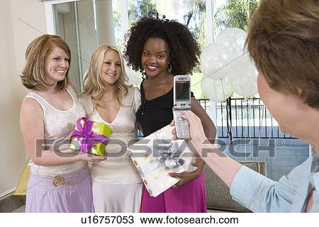 Woman Taking Pictures of women friends at Party View Large Photo Image Stock Image - Woman Taking Pictures of women friends at Party. Fotosearch