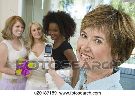Woman Taking Pictures of women friends at Party View Large Photo Image Stock Photo - Woman Taking Pictures of women friends at Party. Fotosearch