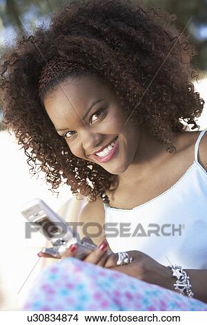 Picture - Woman texting on mobile phone, portrait, (portrait). Fotosearch