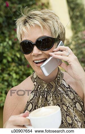 Picture - Woman using mobile phone outdoors. Fotosearch