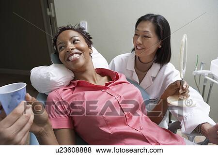 Stock Photo - Woman with dentist in surgery. Fotosearch