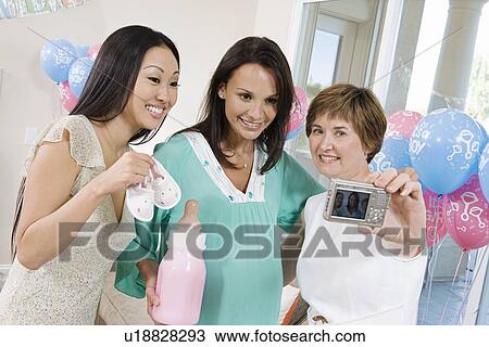 Stock Image - Women at a Baby Shower using Digital camera. Fotosearch