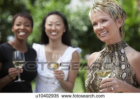 Stock Photography - Women drinking wine in the garden. Fotosearch