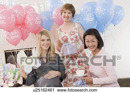 Stock Image - Women Holding Gifts at a Baby Shower. Fotosearch