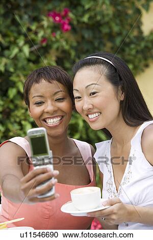 Women photographing themselves outdoors View Large Photo Image Stock Image - Women photographing themselves outdoors. Fotosearch