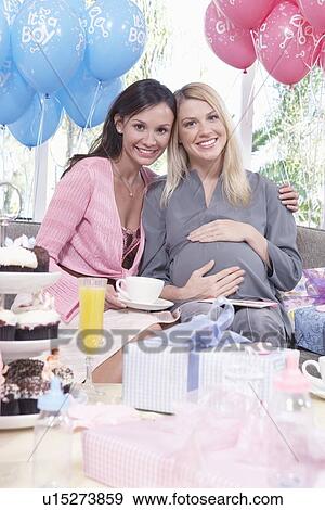 Women sitting on sofa at baby shower View Large Photo Image Stock Photo - Women sitting on sofa at baby shower. Fotosearch