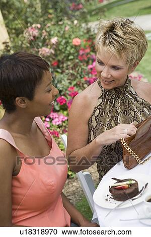 Stock Image - Women talking at outdoor table. Fotosearch