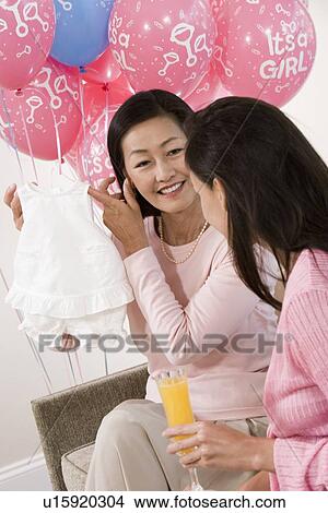 Picture - Women with Baby Clohtes as a Baby Shower. Fotosearch