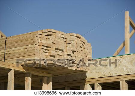 Wooden planks stacked on house construction View Large Photo Image Stock Photograph - Wooden planks stacked on house construction. Fotosearch