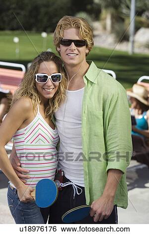 Stock Photograph - Young couple playing table tennis, portrait. Fotosearch