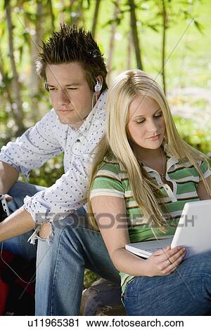 Stock Image - Young couple relaxing outdoors. Fotosearch