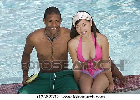 Young Couple Sitting by Swimming Pool, Portrait View Large Photo Image Stock Image - Young Couple Sitting by Swimming Pool, Portrait. Fotosearch