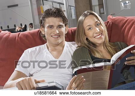 Young couple studying together on couch in common room View Large Photo Image Picture - Young couple studying together on couch in common room. Fotosearch