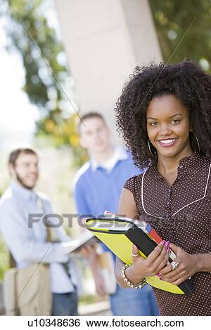 Young female student holding books View Large Photo Image Stock Photograph - Young female student holding books. Fotosearch