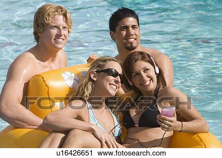 Stock Image - Young Friends at Swimming Pool. Fotosearch