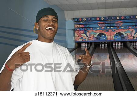 Young man at bowling alley celebrating, portrait View Large Photo Image Stock Image - Young man at bowling alley celebrating, portrait. Fotosearch