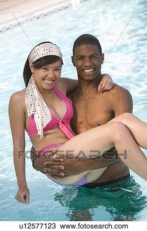 Young Man Carrying Young Woman in Swimming Pool, Portrait View Large Photo Image Stock Image - Young Man Carrying Young Woman in Swimming Pool, Portrait. Fotosearch