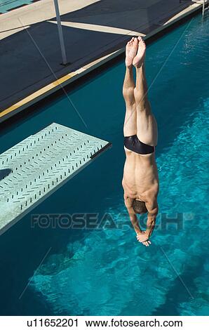 Stock Image - Young man diving into swimming pool. Fotosearch