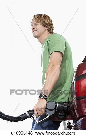 Young man filling car with gasoline View Large Photo Image Stock Photo - Young man filling car with gasoline. Fotosearch