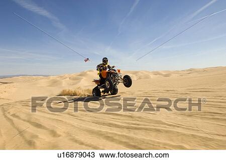 Young Man Riding ATV Over Sand Dune View Large Photo Image Stock Image - Young Man Riding ATV Over Sand Dune. Fotosearch