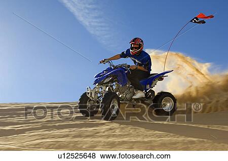 Young Man Riding ATV Over Sand Dune View Large Photo Image Stock Photo - Young Man Riding ATV Over Sand Dune. Fotosearch