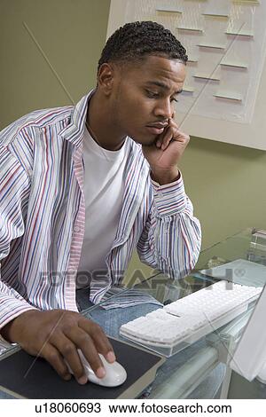 Stock Image - Young Man Using Desktop Computer. Fotosearch