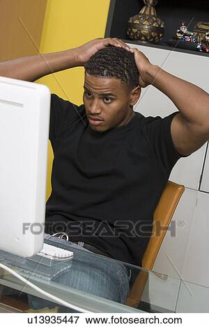 Stock Photo - Young Man Using Desktop Computer. Fotosearch