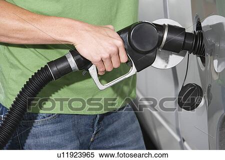 Young man with fuel pump, mid section View Large Photo Image Stock Photography - Young man with fuel pump, mid section. Fotosearch
