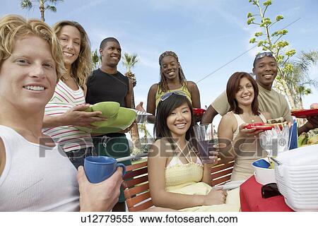 Stock Photography - Young people eating outside in summer. Fotosearch