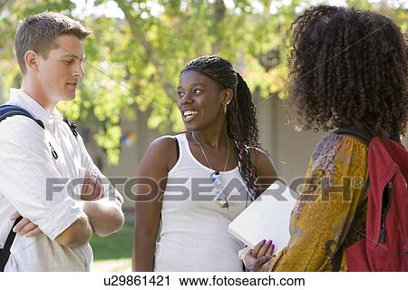 Stock Image - Young students having a chat. Fotosearch