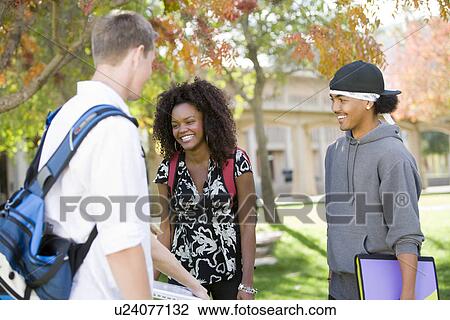 Stock Image - Young students having chat. Fotosearch