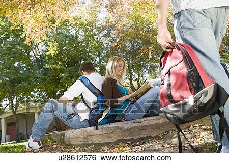 Stock Photograph - Young students reading in park. Fotosearch