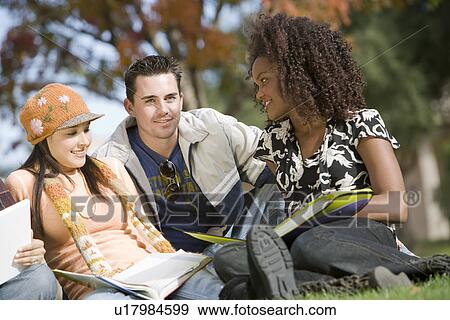 Young students sitting on grass View Large Photo Image Stock Photo - Young students sitting on grass. Fotosearch