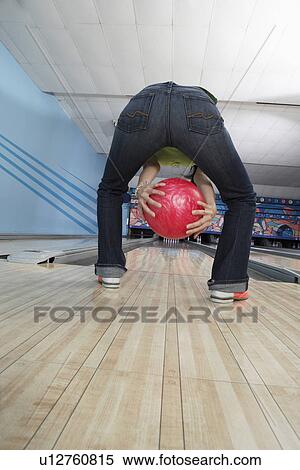Stock Photography - Young woman bowling, back view. Fotosearch