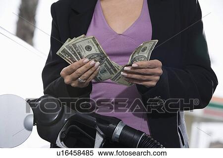 Young woman counting money at service station View Large Photo Image Stock Photography - Young woman counting money at service station. Fotosearch