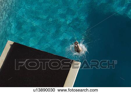 Young woman diving into swimming pool View Large Photo Image Stock Image - Young woman diving into swimming pool. Fotosearch