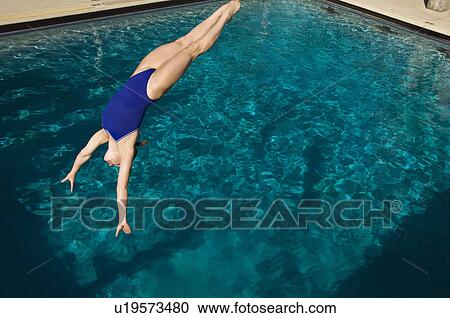 Young woman diving into swimming pool View Large Photo Image Stock Image - Young woman diving into swimming pool. Fotosearch
