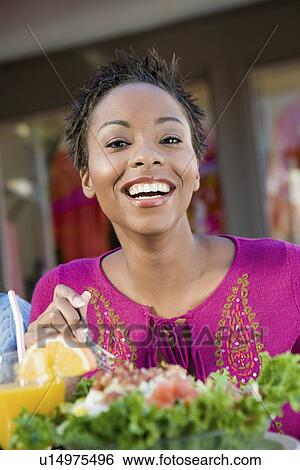 Stock Photograph - Young woman eating salad, portrait. Fotosearch