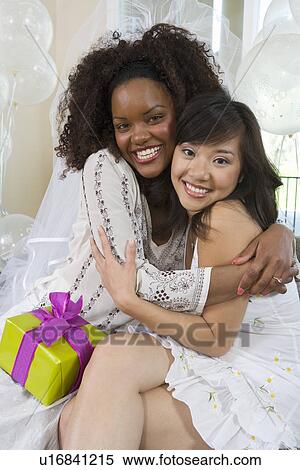 Young woman embracing friend at bridal shower View Large Photo Image Stock Photography - Young woman embracing friend at bridal shower. Fotosearch