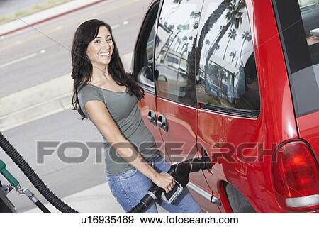 Young woman filling car with gas at gas station, elevated view View Large Photo Image Stock Photo - Young woman filling car with gas at gas station, elevated view. Fotosearch