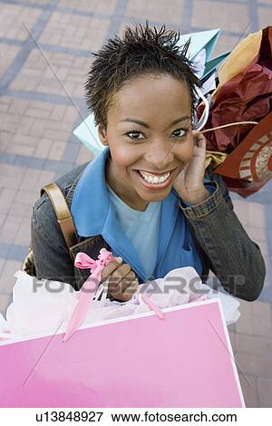 Young woman holding shopping bags, elevated view, portrait View Large Photo Image Stock Photo - Young woman holding shopping bags, elevated view, portrait. Fotosearch