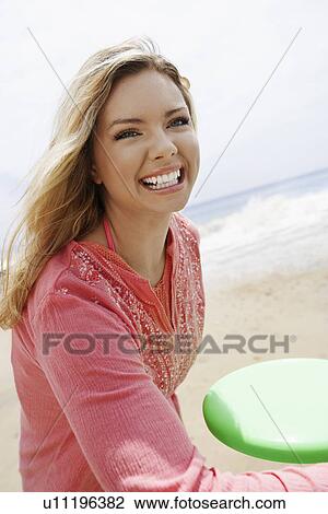 Young woman playing Frisbee on beach View Large Photo Image Stock Image - Young woman playing Frisbee on beach. Fotosearch