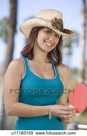 Stock Photo - Young woman playing table tennis, portrait. Fotosearch