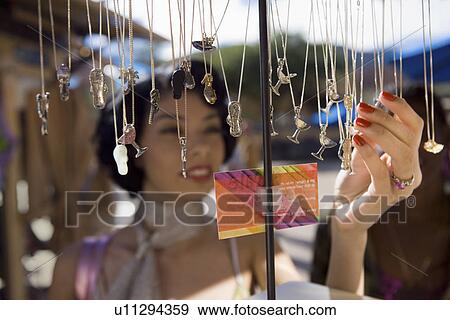 Young woman shopping for necklaces View Large Photo Image Stock Photo - Young woman shopping for necklaces. Fotosearch