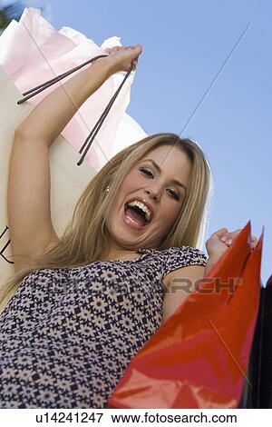 Young woman with shopping bags, outdoors, (portrait) View Large Photo Image Stock Photo - Young woman with shopping bags, outdoors, (portrait). Fotosearch